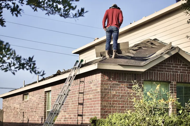 Professional roofer working on a residential roof in Meadows of Bloomfield